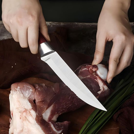 Chef désossant viande blanche avec couteau de cuisine professionnel