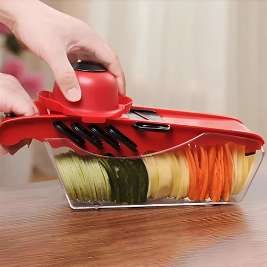 Bac collecteur transparent du coupe-légumes Multivit rempli de tranches parfaites de concombre, pomme de terre et carotte multicolores