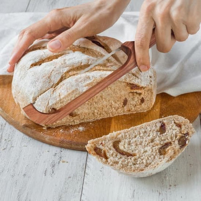 couteau à pain coupe sur une planche en bois, un pain de campagne