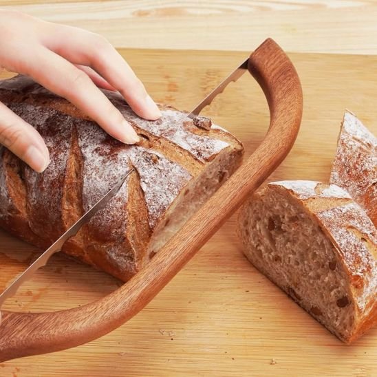 couteau à pain main qui tient un pain de campagne