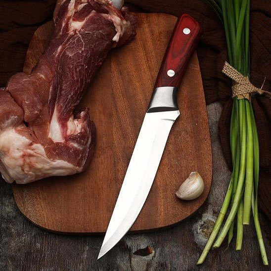 Couteau de cuisine à désosser professionnel avec viande crue et légumes