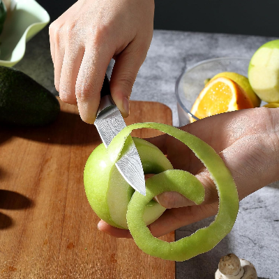 Couteau d'office japonais Damas épluchant peau de pomme en spirale