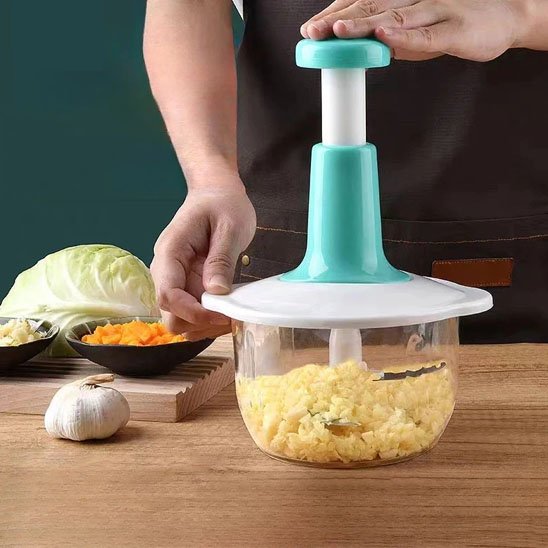 Hachoir manuel triple lames en train de hacher des cubes de fromage